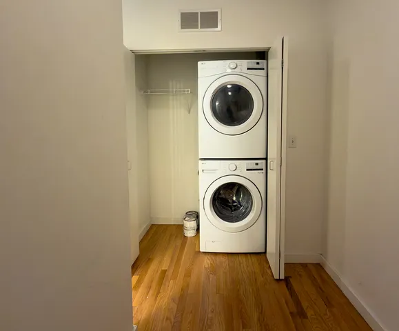 a utility room with wooden floor and a washer dryer