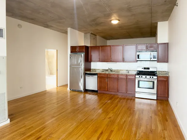 a kitchen with granite countertop wooden floors and stainless steel appliances