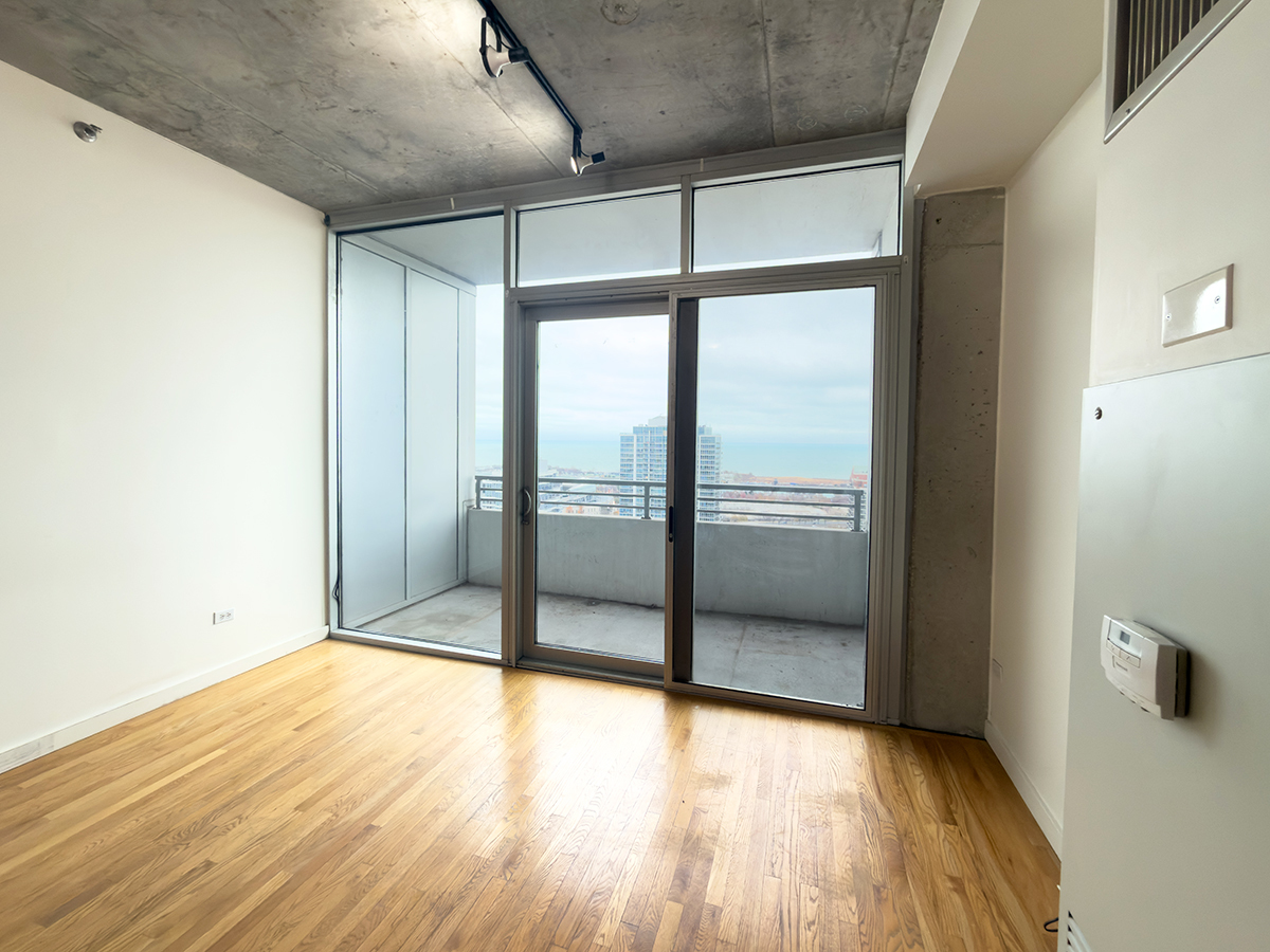 1720 South Michigan Avenue, Unit 3002 Chicago, IL 60616 - Photo 6 of 22 a view of an empty room with wooden floor and a window