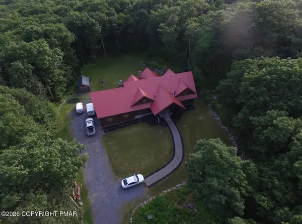 an aerial view of a house with garden space and lake view