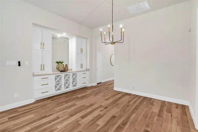a view of a room with cabinet wooden floor and chandelier