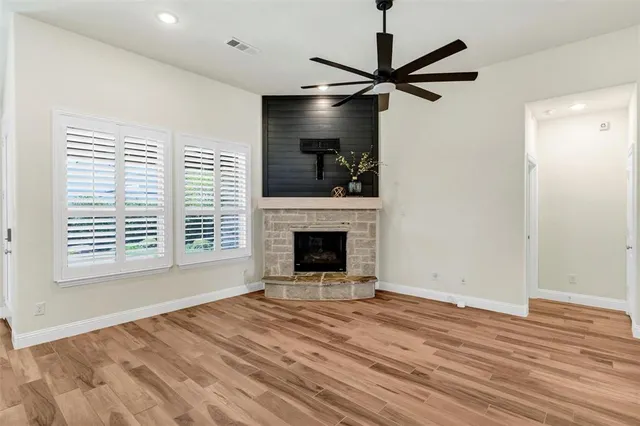 a view of an empty room with a fireplace and a window