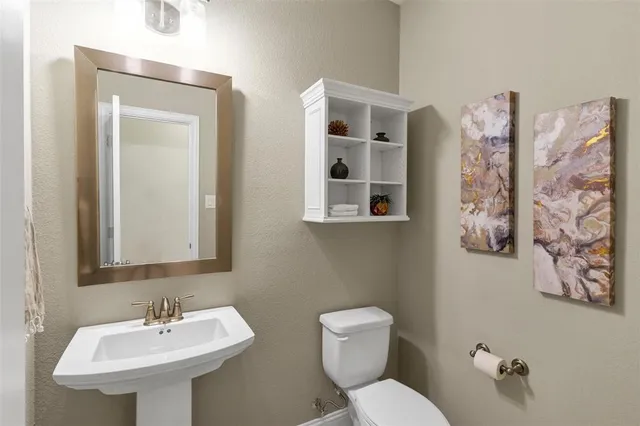 a bathroom with a toilet sink and mirror