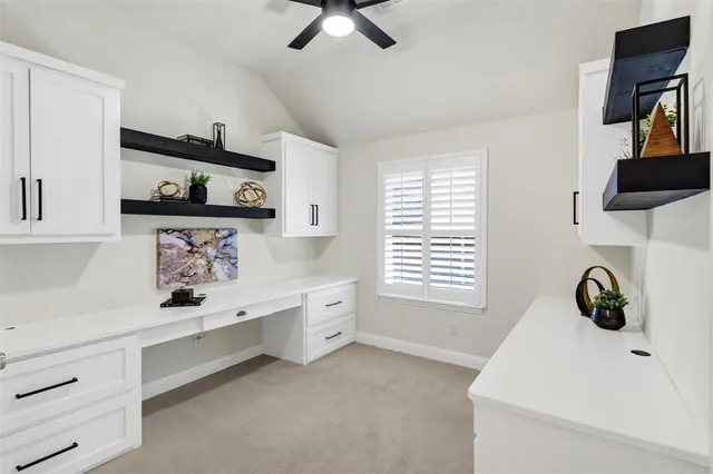 a kitchen with white cabinets and window
