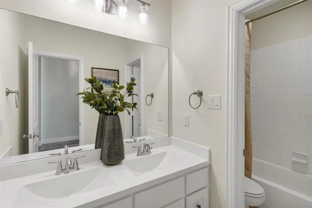 a bathroom with a granite countertop sink a toilet and shower
