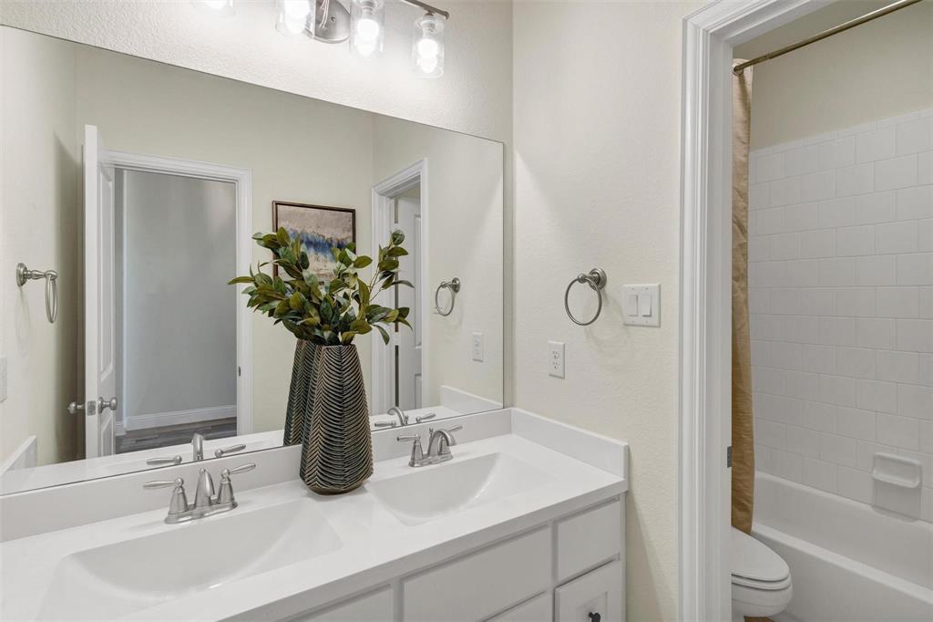 1928 Crested Ridge Road Fort Worth, TX 76008 - Photo 21 of 29 a bathroom with a granite countertop sink a toilet and shower