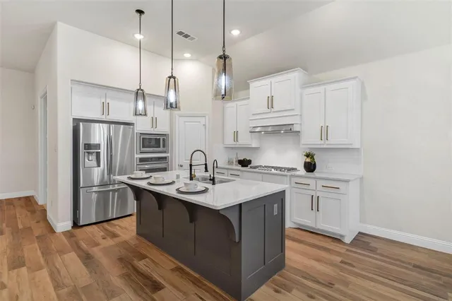 a kitchen with stainless steel appliances granite countertop a sink stove and refrigerator