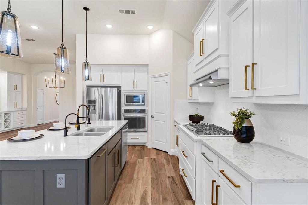 1928 Crested Ridge Road Fort Worth, TX 76008 - Photo 7 of 29 a kitchen with stainless steel appliances granite countertop a sink a stove and a wooden floors