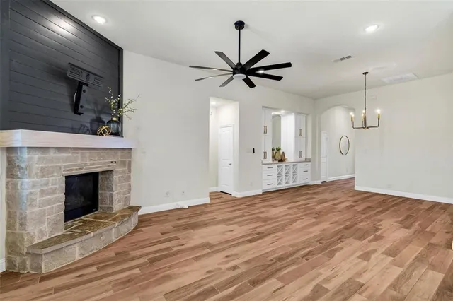 a view of empty room with wooden floor and a fireplace
