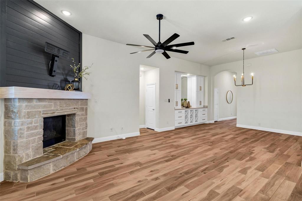 1928 Crested Ridge Road Fort Worth, TX 76008 - Photo 9 of 29 a view of empty room with wooden floor and a fireplace