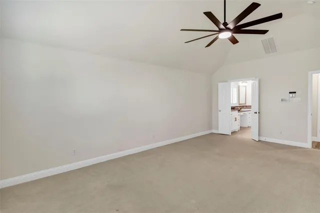 an empty room with a ceiling fan and window