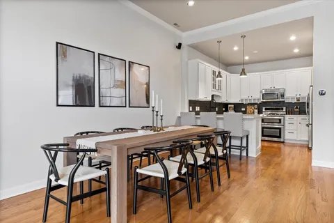 a kitchen with stainless steel appliances kitchen island granite countertop a table chairs sink and cabinets