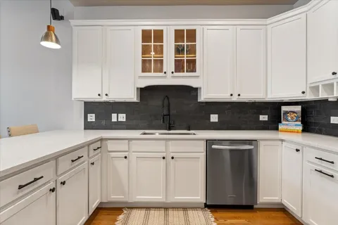 a kitchen with white cabinets and sink