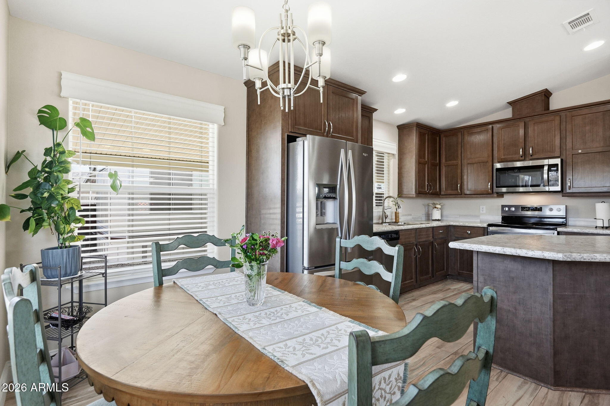 8865 East Baseline Road, Unit 1417 Mesa, AZ 85209 - Photo 3 of 47 a kitchen with sink refrigerator dining table and chairs