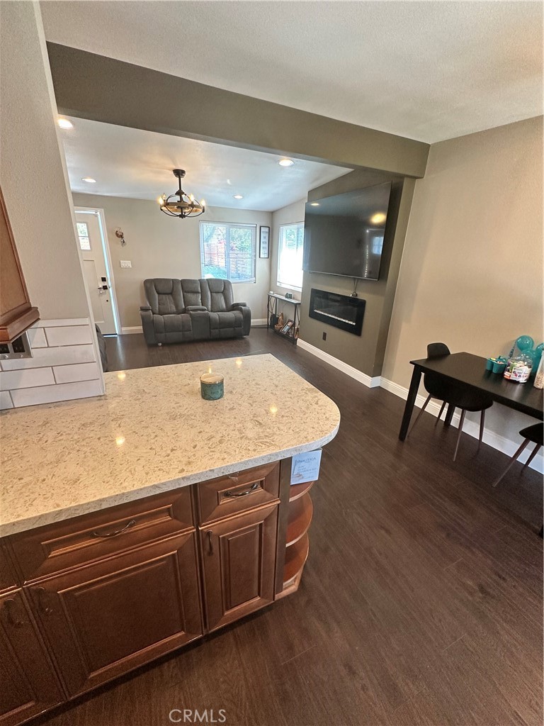 18470 7th Street Bloomington, CA 92316 - Photo 22 of 45 a living room with stainless steel appliances kitchen island granite countertop a sink a stove and wooden floor