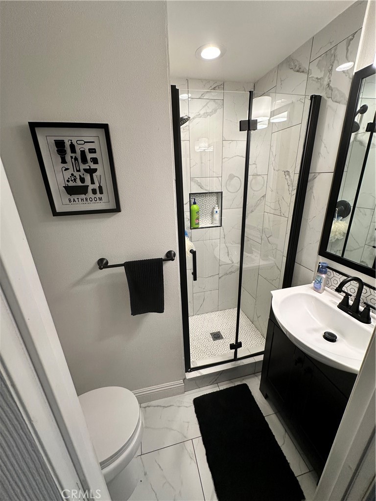 18470 7th Street Bloomington, CA 92316 - Photo 7 of 45 a bathroom with a sink a toilet a mirror and shower