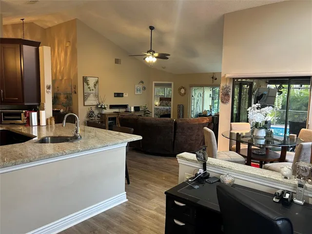 a view of a kitchen with kitchen island granite countertop a sink and a large window