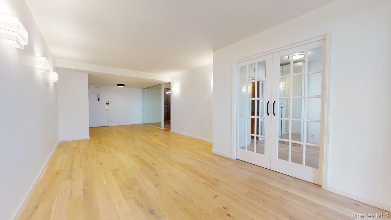 118-17 Union Turnpike, Unit 18H Queens, NY 11375 - Photo 13 of 49 Unfurnished room featuring light wood-type flooring and french doors