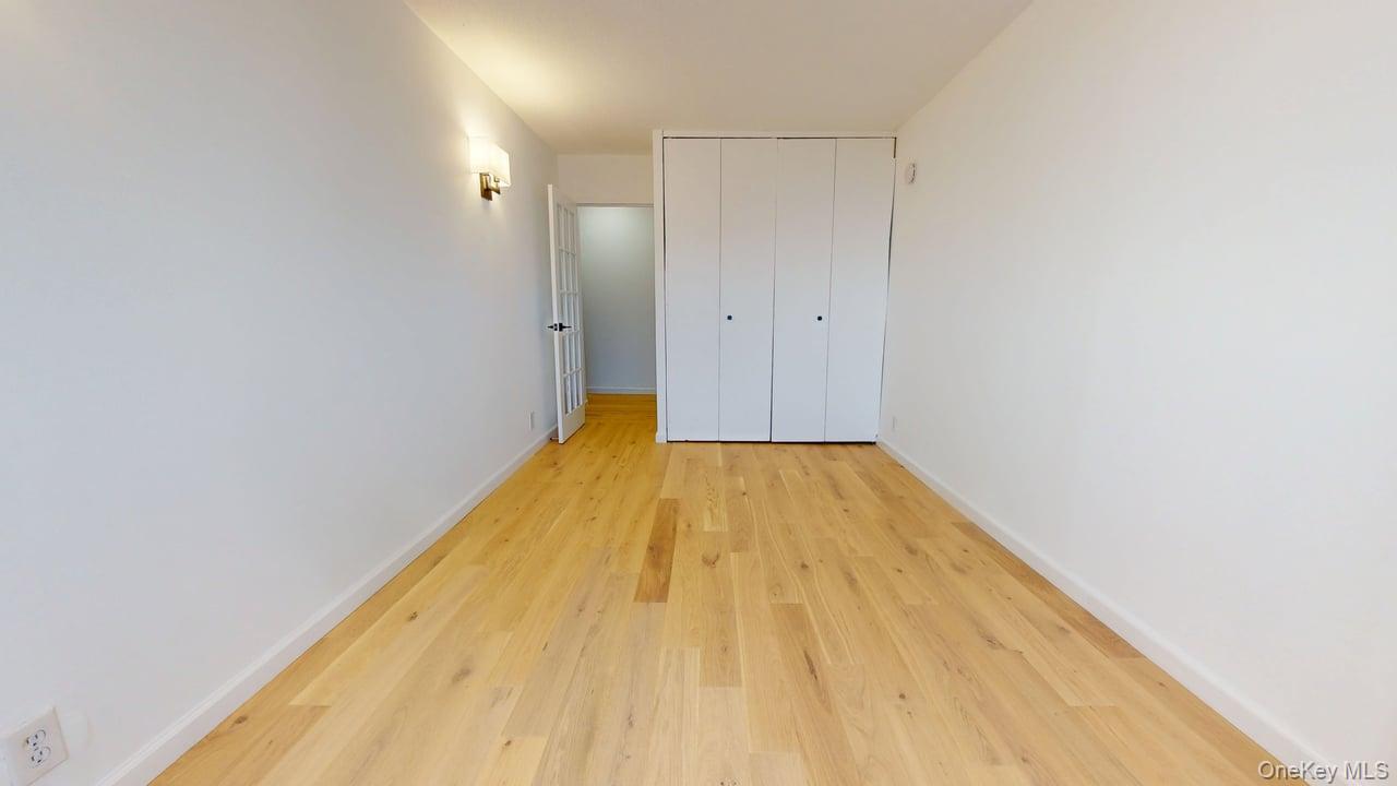118-17 Union Turnpike, Unit 18H Queens, NY 11375 - Photo 25 of 49 Unfurnished bedroom featuring light wood-style flooring and a closet