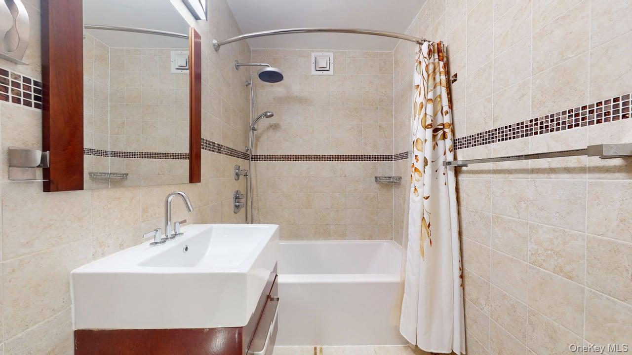 118-17 Union Turnpike, Unit 18H Queens, NY 11375 - Photo 36 of 49 Full bath with tile walls, shower / bath combo, and vanity