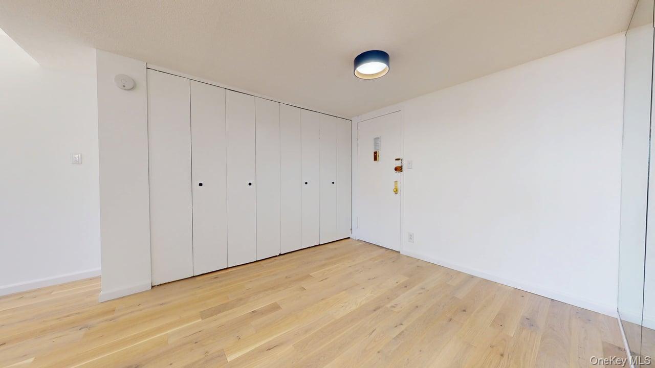 118-17 Union Turnpike, Unit 18H Queens, NY 11375 - Photo 5 of 49 Unfurnished bedroom with light wood-type flooring and a closet