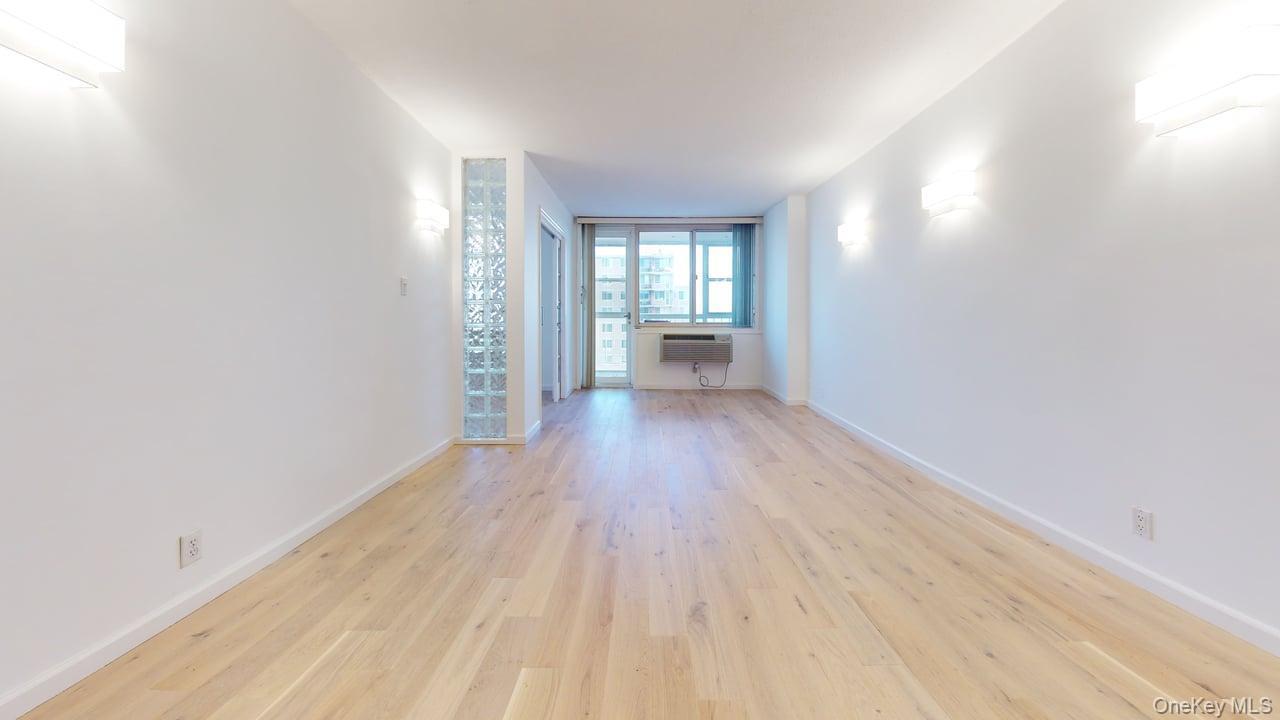 118-17 Union Turnpike, Unit 18H Queens, NY 11375 - Photo 6 of 49 Spare room featuring light wood-type flooring and baseboards