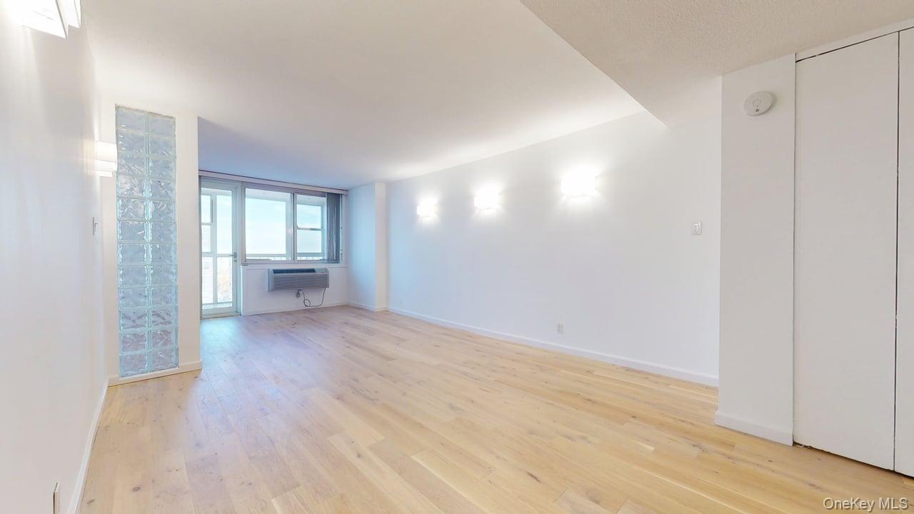 118-17 Union Turnpike, Unit 18H Queens, NY 11375 - Photo 7 of 49 Spare room featuring light wood-style floors and baseboards