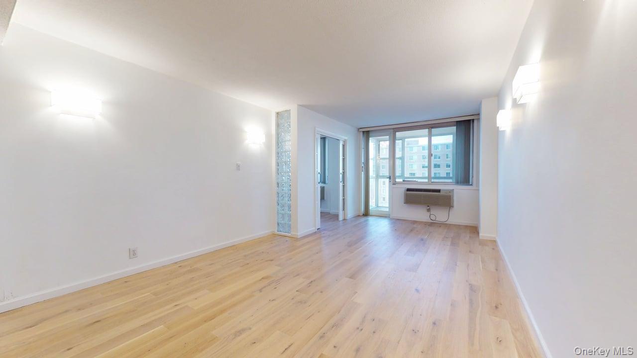 118-17 Union Turnpike, Unit 18H Queens, NY 11375 - Photo 8 of 49 Unfurnished room featuring light wood-type flooring and baseboards