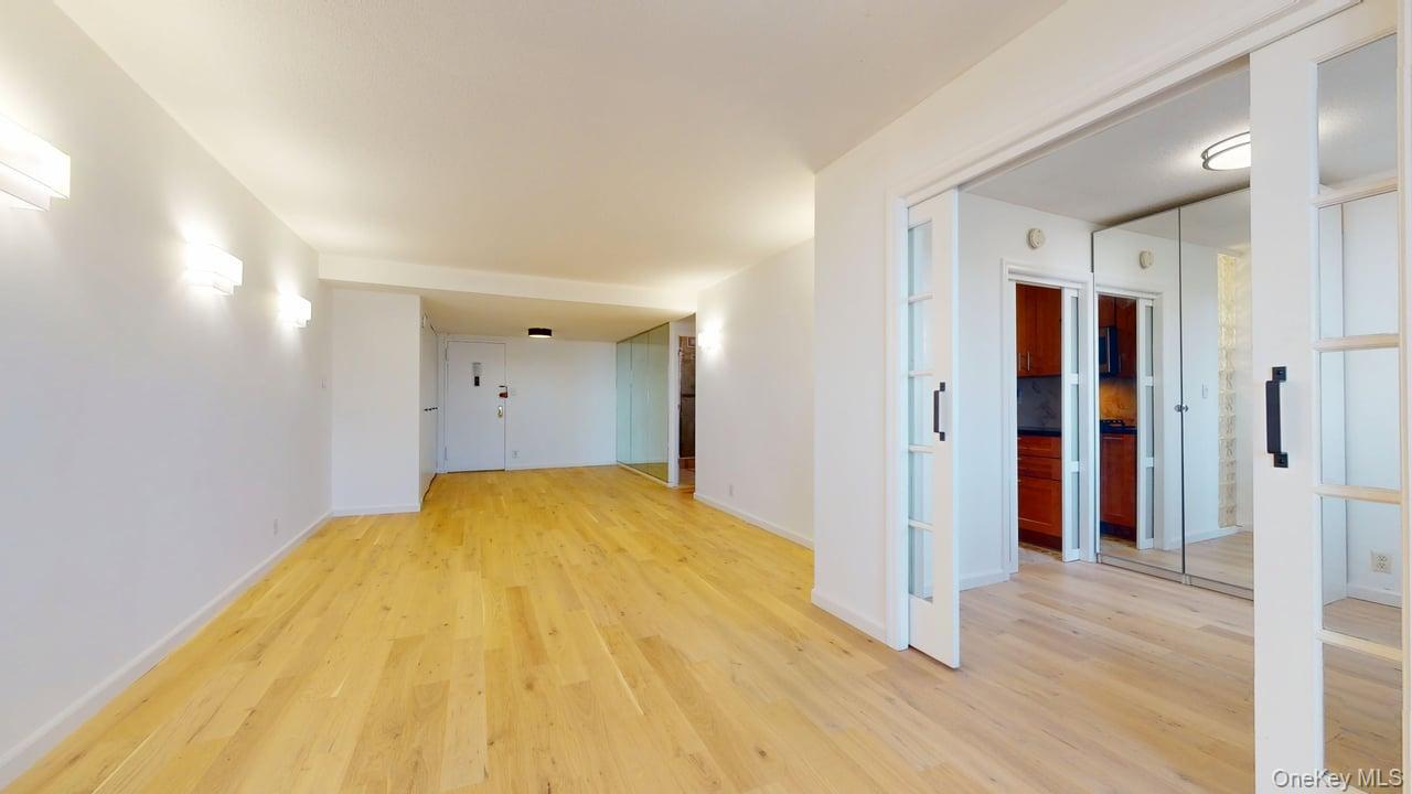 118-17 Union Turnpike, Unit 18H Queens, NY 11375 - Photo 10 of 49 Spare room featuring light wood-style floors and baseboards
