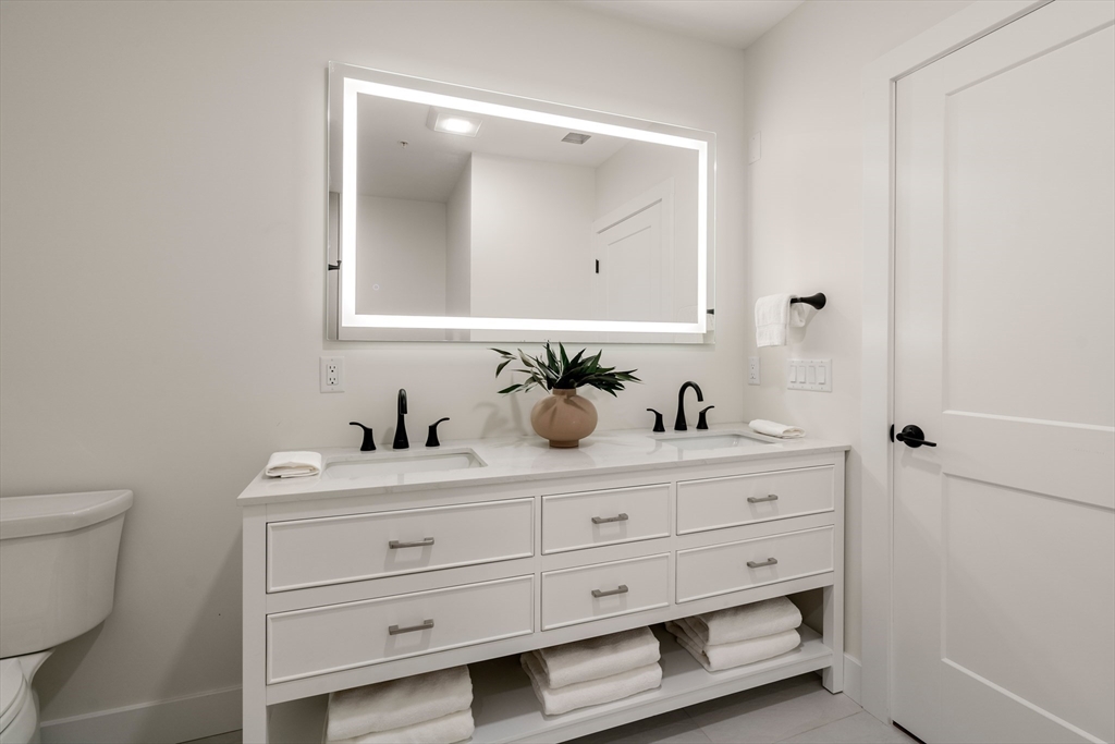 20 Audubon Way, Unit 302 Canton, MA 02021 - Photo 15 of 22 a bathroom with a toilet sink and mirror