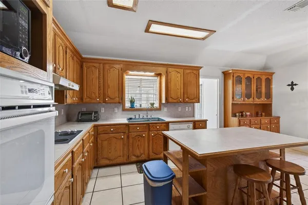 a kitchen with a sink a stove a table and chairs