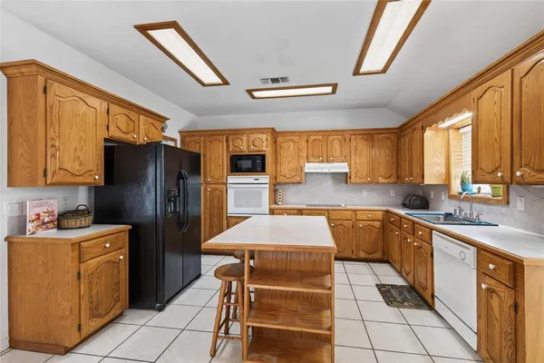 a kitchen with stainless steel appliances a stove refrigerator sink and cabinets
