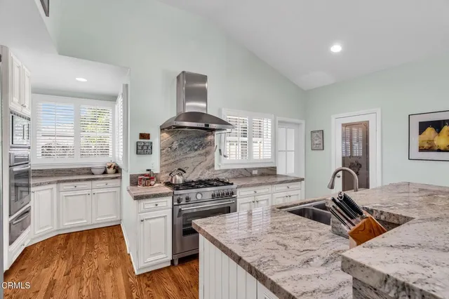 a kitchen with granite countertop cabinets stainless steel appliances and a dining table