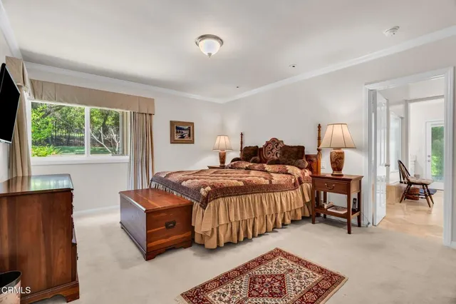 a bedroom with a bed and a flat tv screen on the dresser