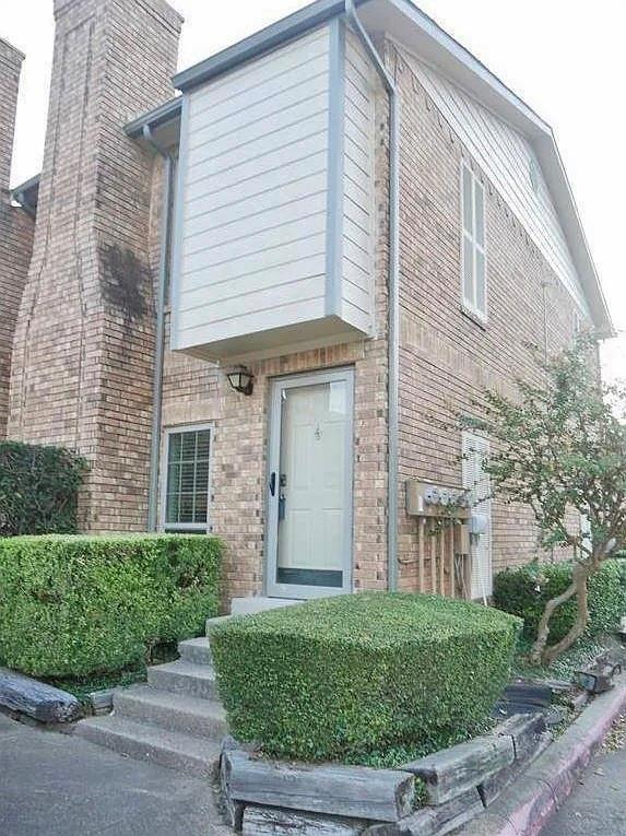 View of exterior entry with brick siding and a chimney