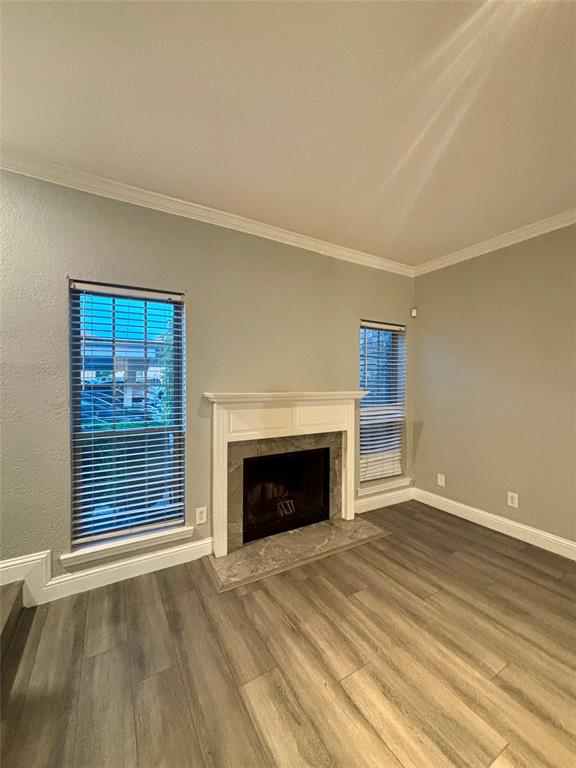 11655 Audelia Road, Unit 1304 Dallas, TX 75243 - Photo 6 of 11 Unfurnished living room featuring ornamental molding, a premium fireplace, and dark wood-type flooring