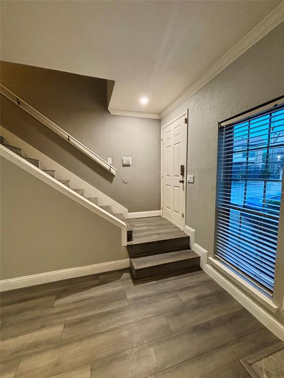 11655 Audelia Road, Unit 1304 Dallas, TX 75243 - Photo 7 of 11 Staircase with wood finished floors, ornamental molding, and a textured wall