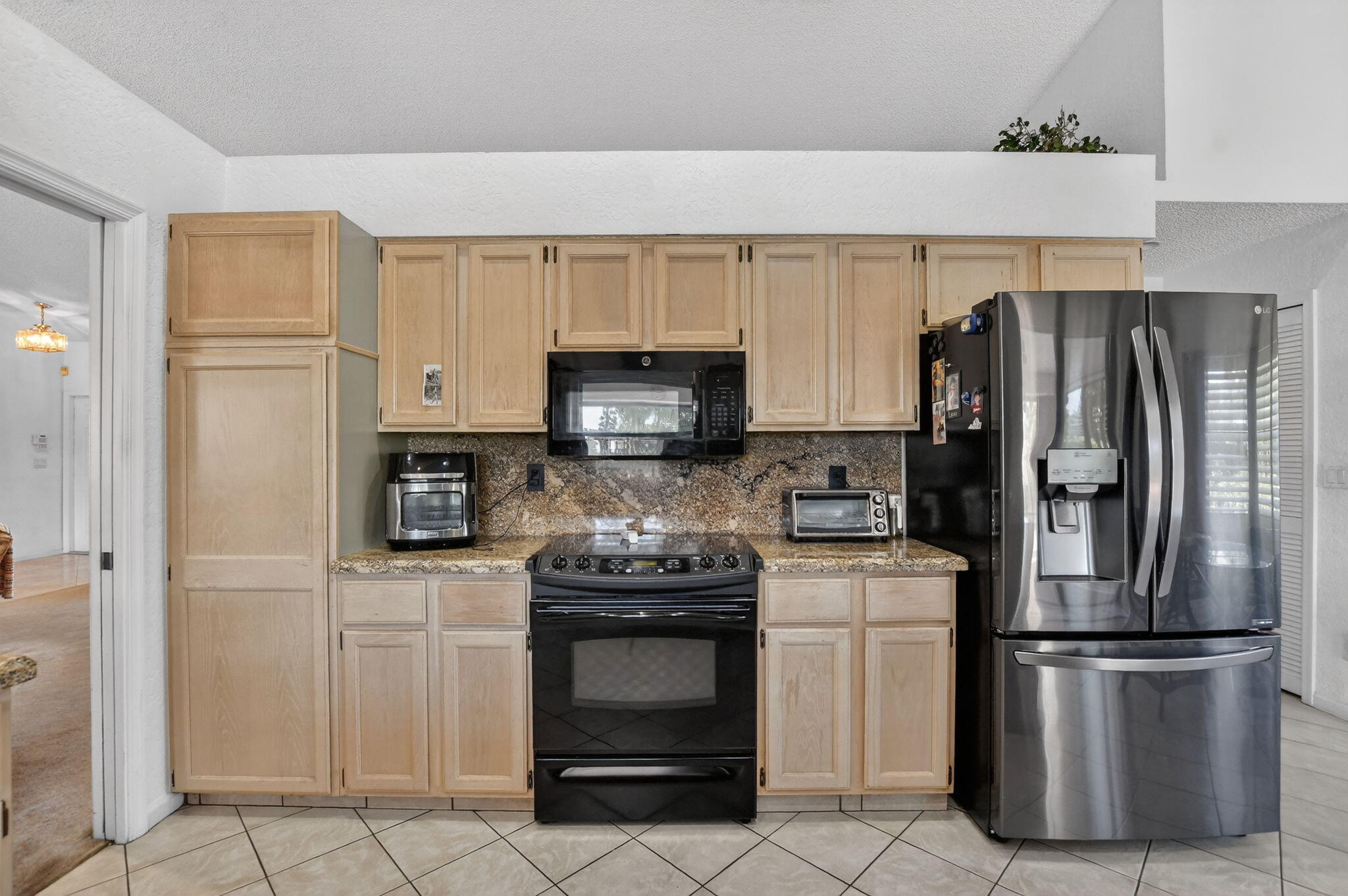 10226 Fresh Meadow Lane Boca Raton, FL 33498 - Photo 14 of 58 a kitchen with white cabinets and stainless steel appliances