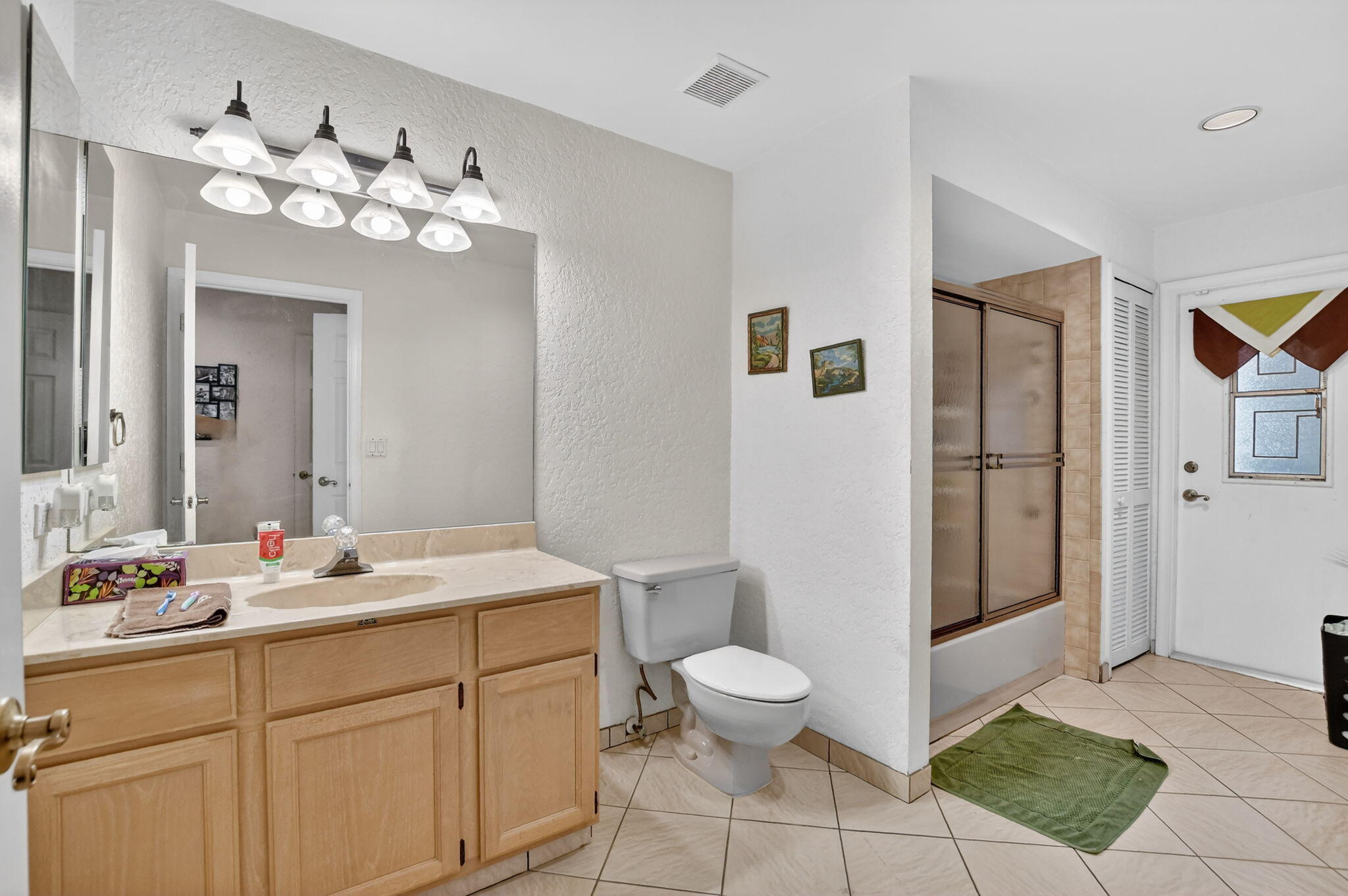 10226 Fresh Meadow Lane Boca Raton, FL 33498 - Photo 29 of 58 a spacious bathroom with a toilet a sink and mirror