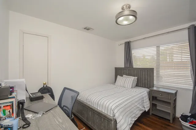 a bedroom with a bed and wooden floor