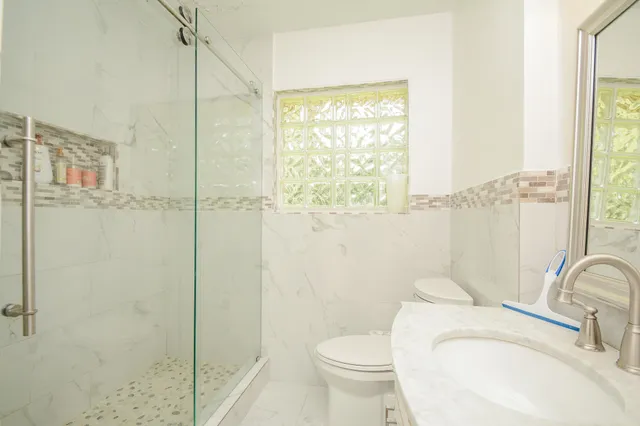 a bathroom with a sink a toilet and shower