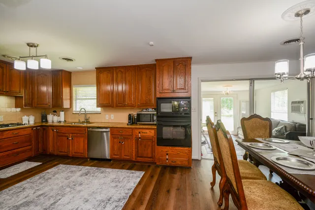 a kitchen with granite countertop lots of wooden cabinets stainless steel appliances