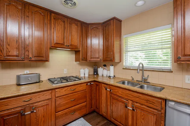 a kitchen with stainless steel appliances granite countertop wooden cabinets a sink and dishwasher