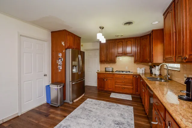 a kitchen with stainless steel appliances granite countertop a refrigerator stove and sink