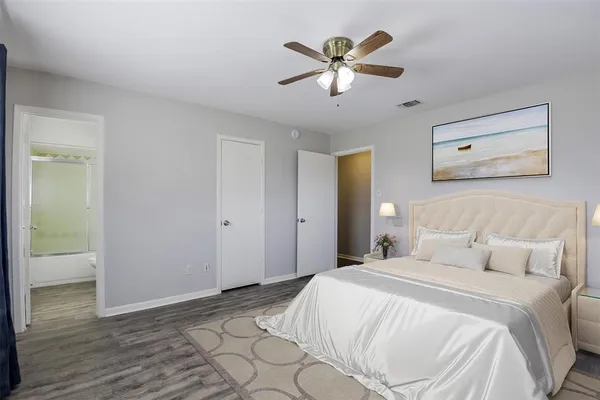 a bedroom with a large bed and a chandelier