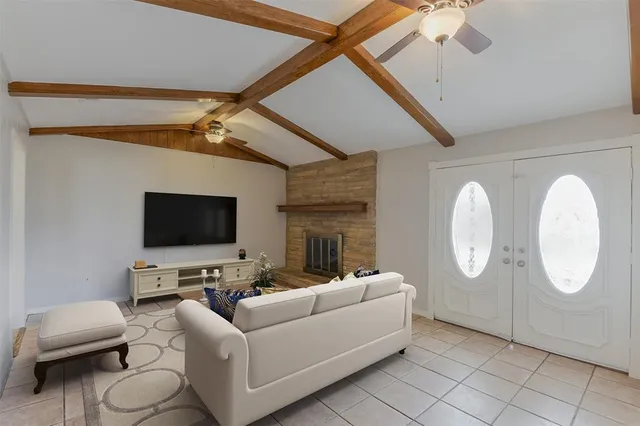 a living room with furniture a fireplace and a flat screen tv
