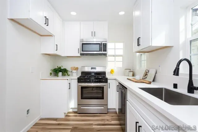 a kitchen with stainless steel appliances granite countertop a sink a stove and a refrigerator