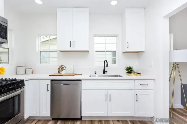 a kitchen with white cabinets and white appliances