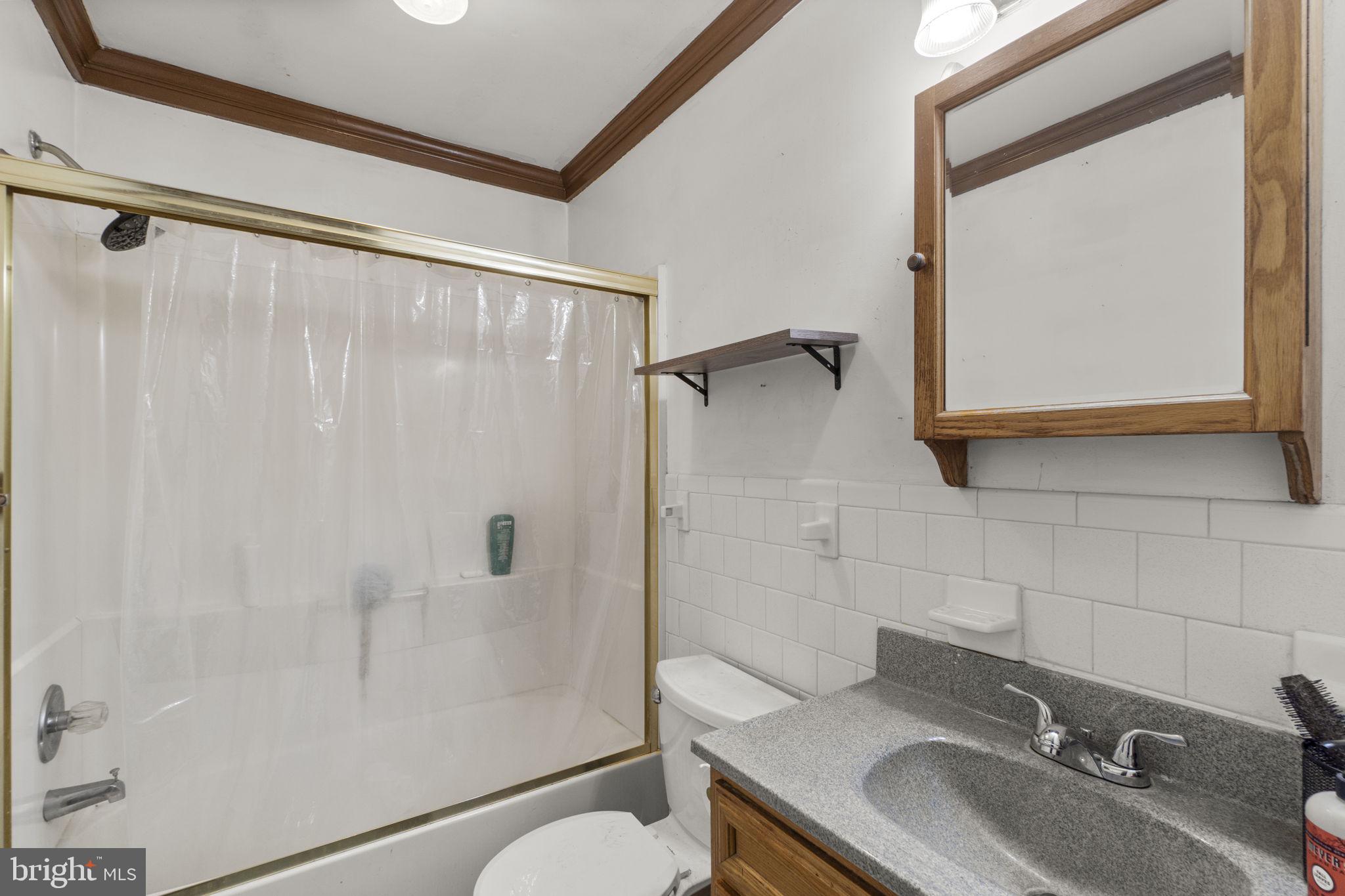6403 Ford Road Frederick, MD 21702 - Photo 12 of 19 a bathroom with a granite countertop sink toilet and shower