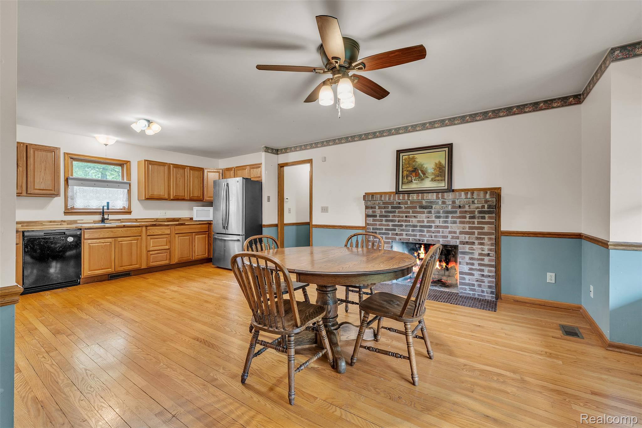 1345 Ives Road Mason, MI 48854 - Photo 18 of 92 Dining room featuring light wood finished floors, ceiling fan, and a brick fireplace